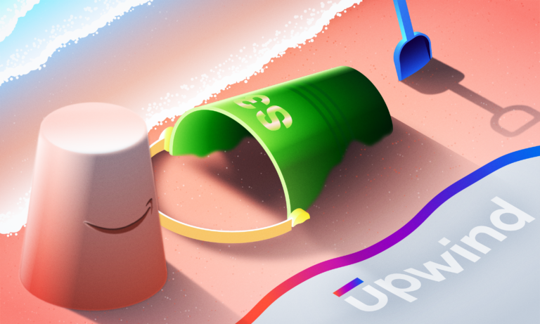 A colorful beach scene featuring an overturned green bucket with S🤝P on it, a pink bucket with a smiley face, and a blue shovel. The word upwind appears on a surface beside them, with waves gently lapping the sandy background.
