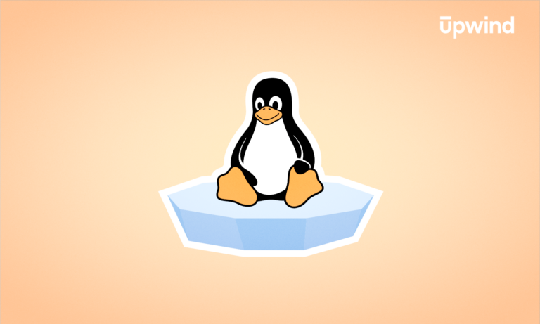 A cartoon penguin sits on a floating piece of ice against a pale orange background, with the upwind logo in the top right corner—a playful nod to “What is the Linux Kernel.”.